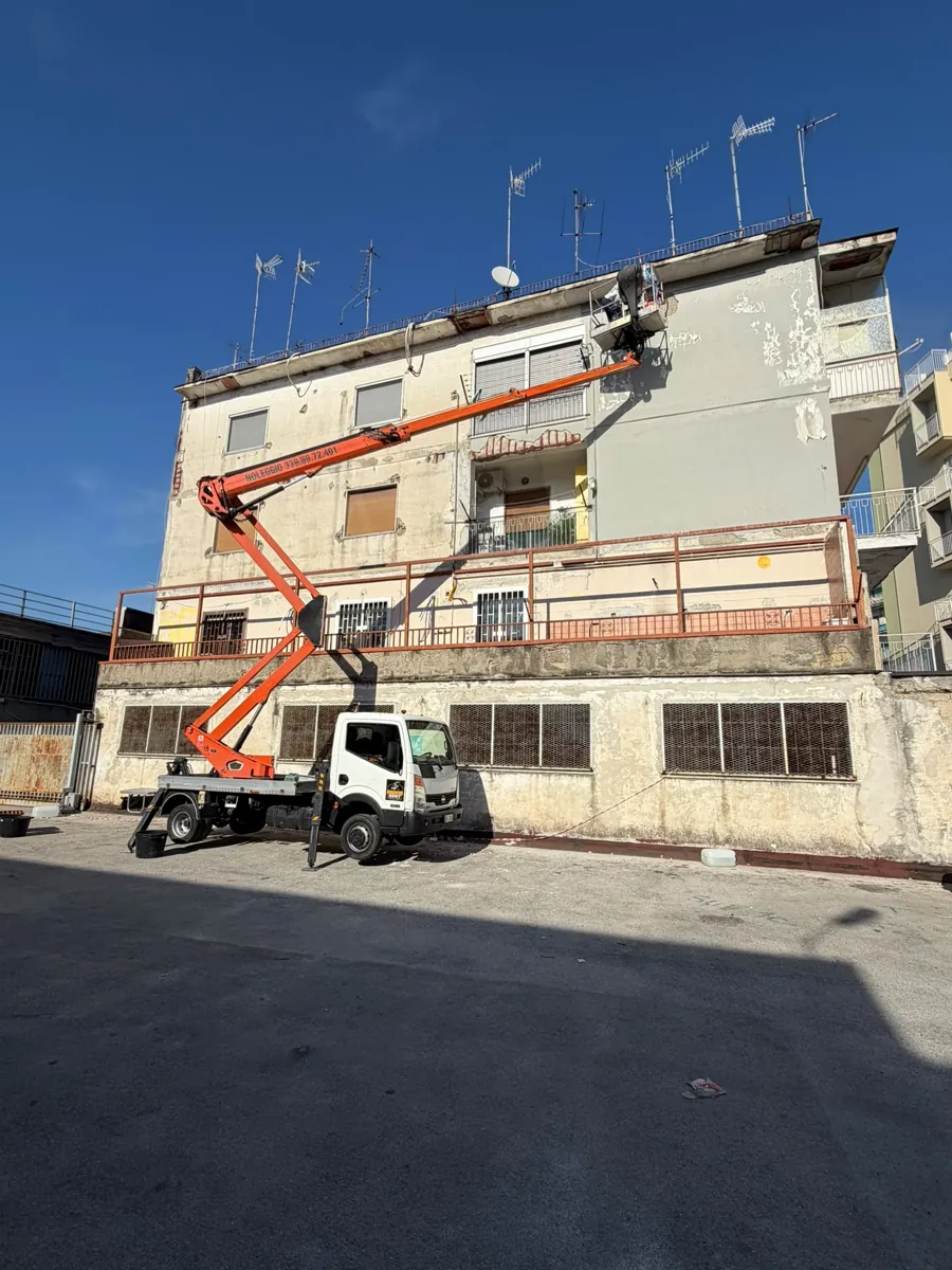 Piattaforma aerea Ruggiero Rent al lavoro sulla facciata di un condominio